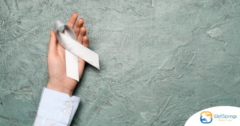 A woman holds a silver ribbon, representing Parkinson’s Awareness Month.